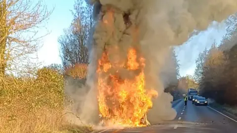 A huge fire on a bus with smoke bellowing out of it