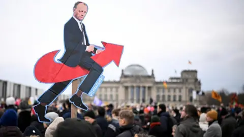 Reuters an effigy of Friedrich Merz riding a red arrow: the logo of the extreme right