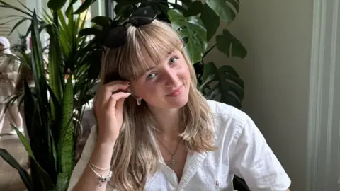 Erin Cruikshank smiles at the camera wearing a white shirt in a BBC handout photo