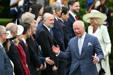 AFP via Getty Images Britain's King Charles III and Queen Camilla greet cabinet members as they arrive for an arrival ceremony on the South Lawn of the White House in Washington, DC, on April 28, 2026
