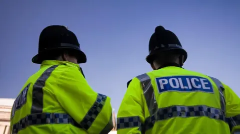 Getty Images Two police officer pictured from behind