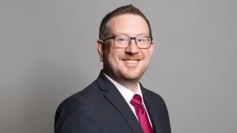 HMC Andrew Gwynne MP official portrait in 2020. Andrew Gwynne is the Labour MP for Denton and Reddish, and has been an MP continuously since 5 May 2005. He currently undertakes the role of Shadow Minister (Social Care).
