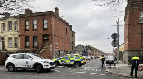 RTÉ Two Garda vehicles parked at the top of a cordon 