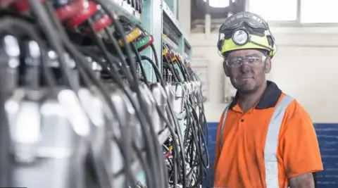 Getty images A miner in front of some equipment 