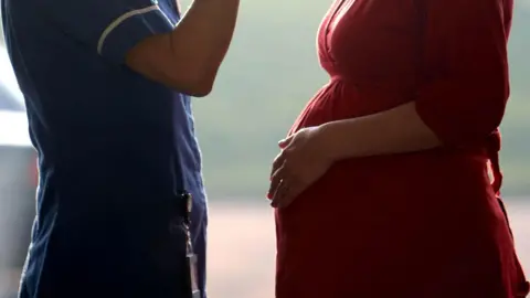 PA A midwife in conversation with a pregnant woman