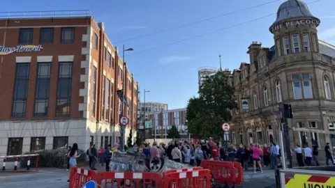 PA Crowds gather for a clean up of the city. A burned out car has been cordoned off