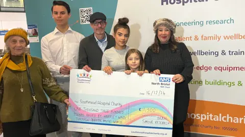 Harriet Anabell and her family stood behind a cheque for the Southmead Hospital Charity. 