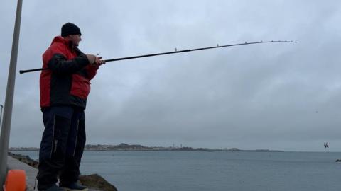 Angler fishing on Guernsey's east coast
