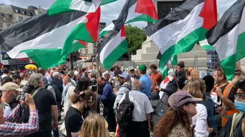 Protesters waving flags in support of Palestine Action in London