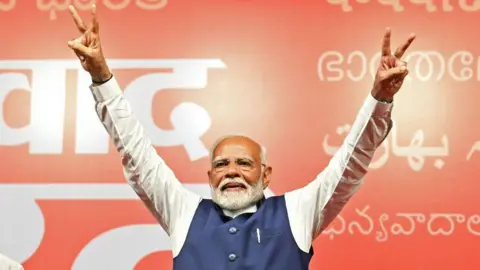  India's Prime Minister Narendra Modi flashes victory sign at the Bharatiya Janata Party (BJP) headquarters to celebrate the party's win in country's general election, in New Delhi on June 4, 2024. 