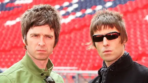 Getty Images Noel and Liam Gallagher at a football ground