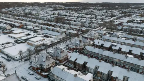 ADAM VAUGHAN/EPA/Shutterstock An aerial view of snow covering rooftops in the Mossley Hill area of Liverpool