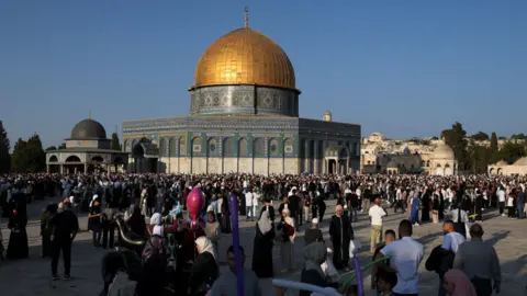 Reuters A golden domed mosque with lots of people wandering around outside it. This is Temple Mount in East Jerusalem, home of the Al Aqsa mosque, and part of a site sacred for all three major world religions