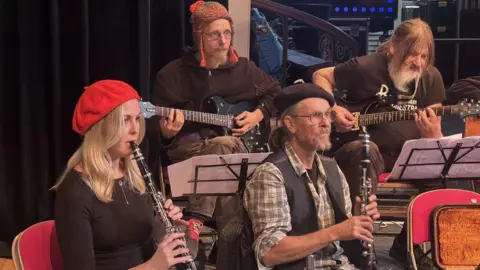 Andy Roberts/BBC Members of the Bristol Recovery Orchestra play a variety of instruments as they rehearse ahead of a Bristol Drugs Project anniversary gala event