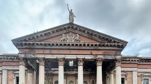Crumlin Road Courthouse - the shot is of the columned portico with the figure of justice on the roof above the royal crest