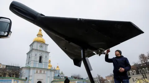A man examines a Russian-Iranian Shahed drone displayed on a plinth outside St Michael's cathedral in central Kyiv