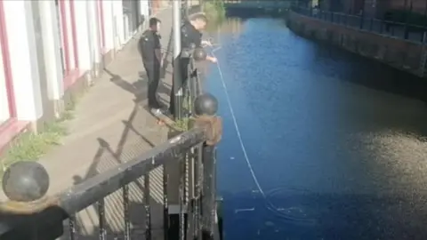 Lewis Bright Police officers trying to scoop out the discovery from the river