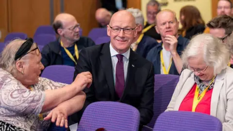 PA Media John Swinney and delegates