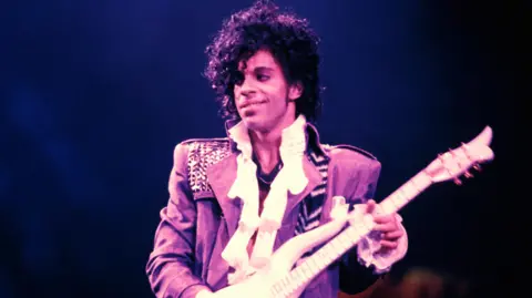 Getty Images Prince playing the guitar on stage in 1984