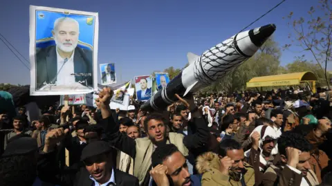 A person carries a mock missile during a rally in solidarity with the Palestinian people, in Sana'a, Yemen, 25 December 2024. 