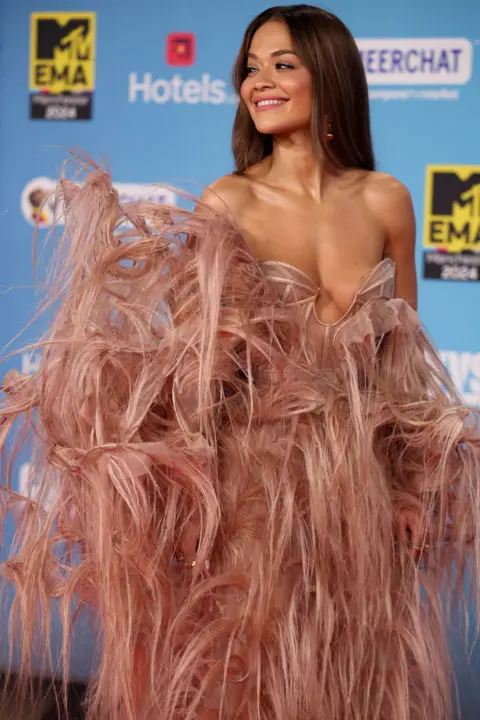 PA Media Rita Ora in an elaborate feathered dress