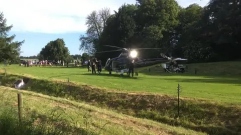 Stapleford Railway A helicopter on a lawn with a waving man dressed in shorts and a T-shirt boarding