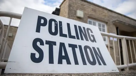 A sign is displayed in front of a polling station in the village of Spelsbury.