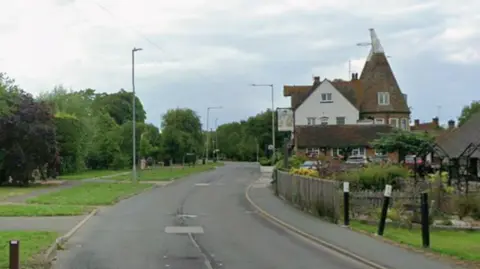 A Google street image of a two-way road with a pub on the right.