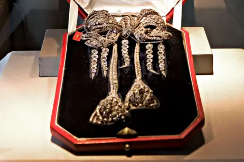 Jb Reed/Bloomberg via Getty Images The antique Empress Eugenie Brooch, an antique diamond bow brooch, pictured in a black velvet box with a red exterior. It is a lavish bow shape with trailing strands of diamonds in the shape of two large tassels, and four further strands hanging from the bow