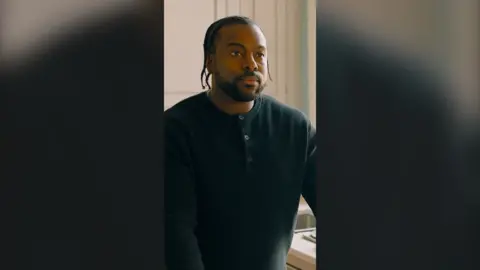 A man, Tevin, has braids and wears a black top.