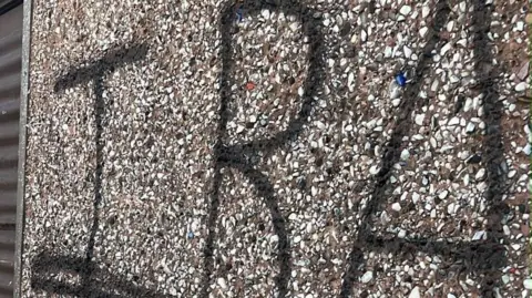 IRA in black spray paint on a pebbledashed wall