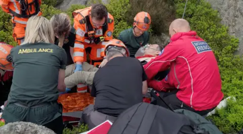 Yorkshire Air Ambulance Paramedics and mountain rescue volunteers lift Mr Foxley onto a stretcher.