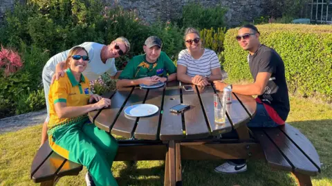 Alice Cant Some members of the St Helena team gathered round a bench in a garden