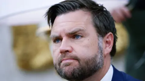 JD Vance, a  bearded man with dark hair and blue eyes