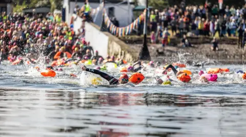 Paul Campbell Swimmers in the water of the Kessock Channel with other swimmers and onlookers in background