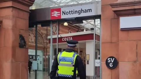 A PCSO walking into the atrium of Nottingham Trailway Station