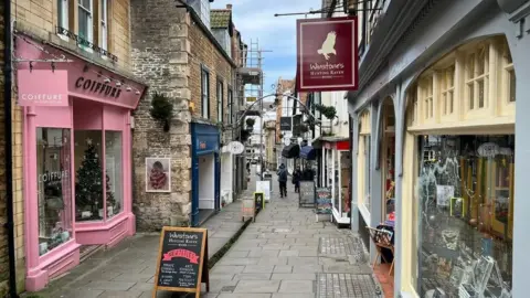 Colourful shops on a pedestrianised lane.