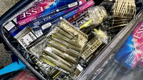 Telford and Wrekin Council An open suitcase with loose tobacco wallets wrapped in clear plastic