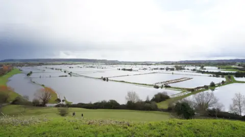 PA Media A large landscape shows fields underwater.