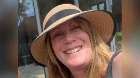 Supplied A selfie-style image of Rebecca Clement. She is wearing a hat and smiling while looking into the camera. 