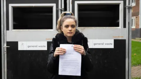 LDRS loretta stands holding her notice letter