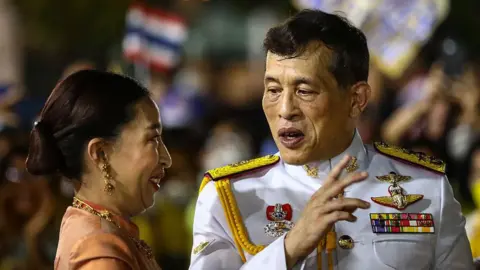AFP via Getty Images Thailand's King Maha Vajiralongkorn talks to Princess Bajrakitiyabha Mahidol as they greet royalist supporters outside the Grand Palace in Bangkok on November 1, 2020 after a religious ceremony at a Buddhist temple inside the palace