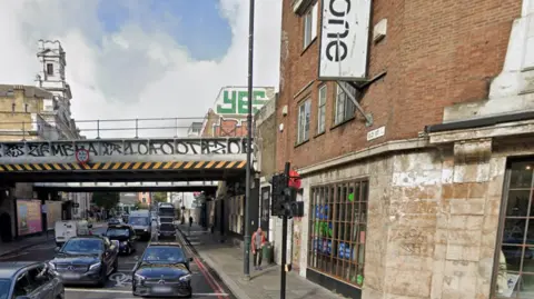 Google Old Street in Shoreditch, with traffic on the road, showing the former Shoreditch railway station, now the Kachette events space.