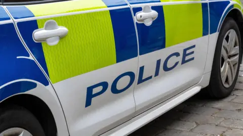 Getty Images Close up of a United Kingdom police patrol response car with Battenberg markings.