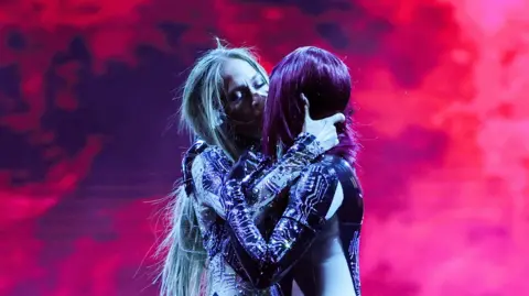 Getty Images J. Lo kissing a dancer on-stage