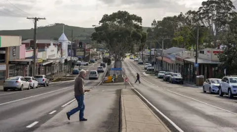 A man crosses the road in a small town 