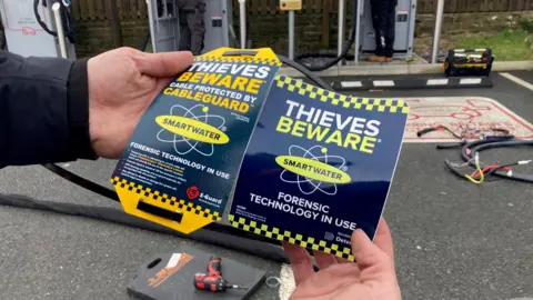 A pair of man's hands holding two brightly coloured warning signs