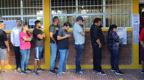 EPA/Shutterstock Men and women queuing up to vote.