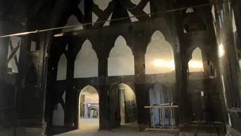 Photograph of the interior of the medieval Baguley Hall in Wythenshawe. The image includes the thick, carved timber frames from the 14th century.