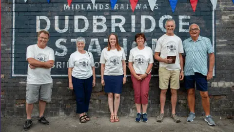Julian Lass A group of three men and three women stood outside Dudbridge station.